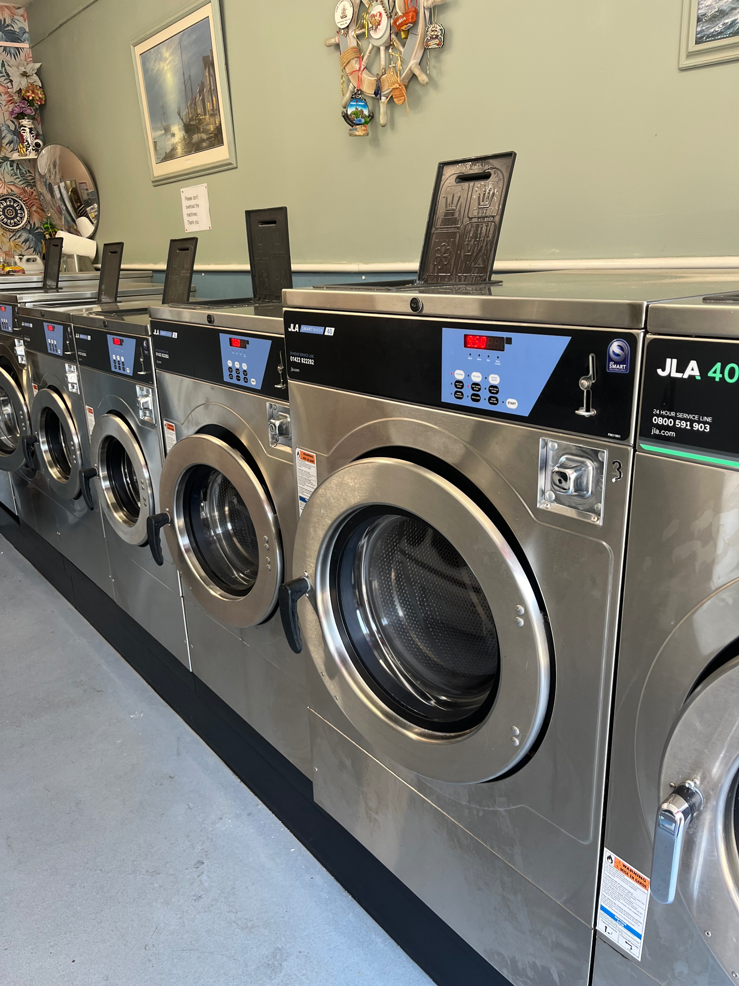 Row of stainless-steel JLA washing machines inside Smart Wash